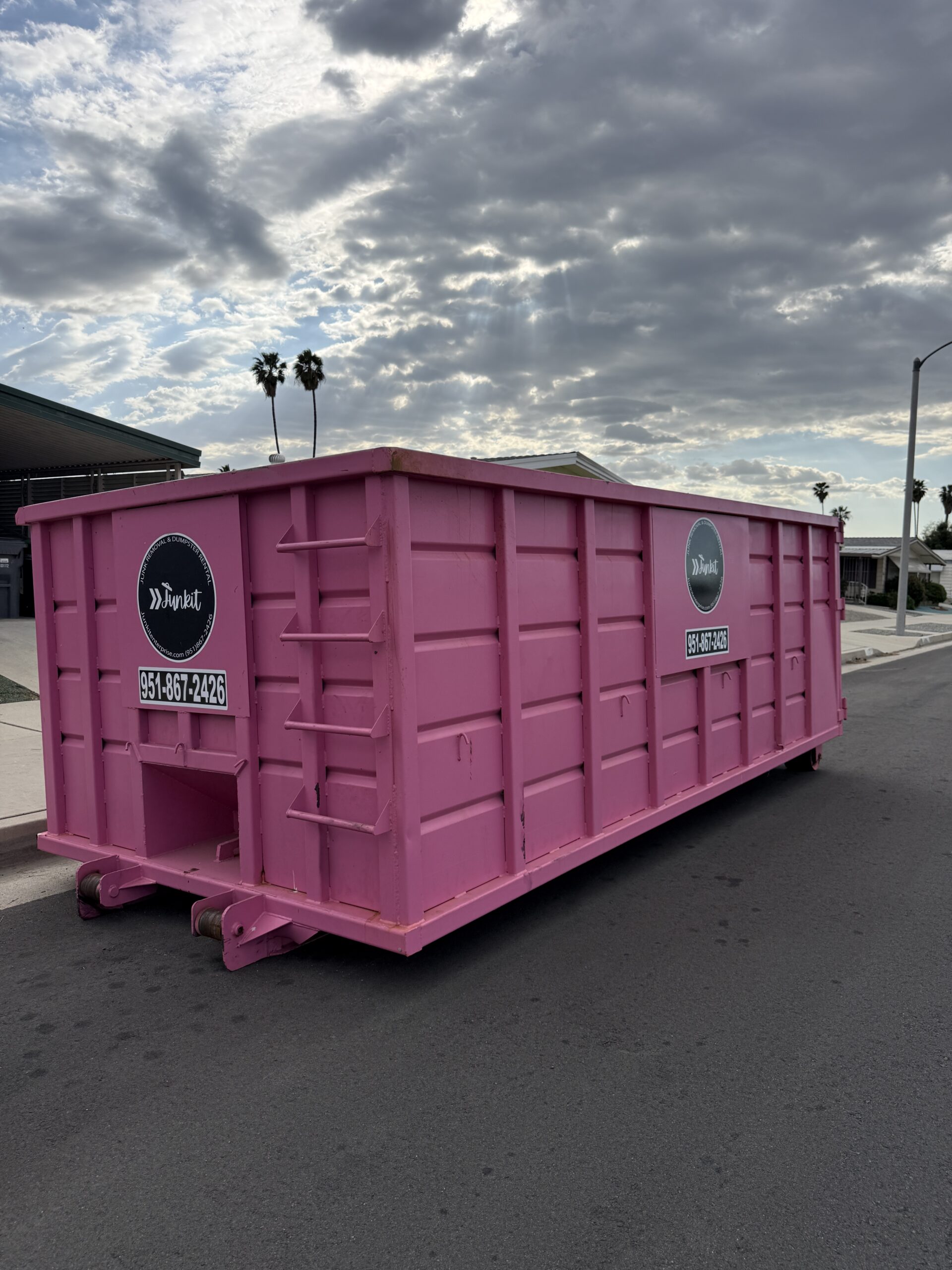 Pink dumpster rental delivered in Hemet CA neighborhood