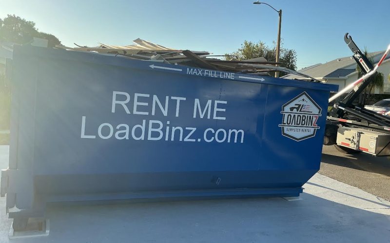 overfilled-loadbinz-dumpster-side-view A side view of a LoadBinz dumpster rental unit parked in a driveway and filled with debris above the 'Max Fill Line'.