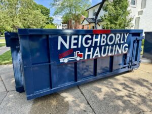 12 yard dumpster on residential driveway with Neighborly Hauling branding