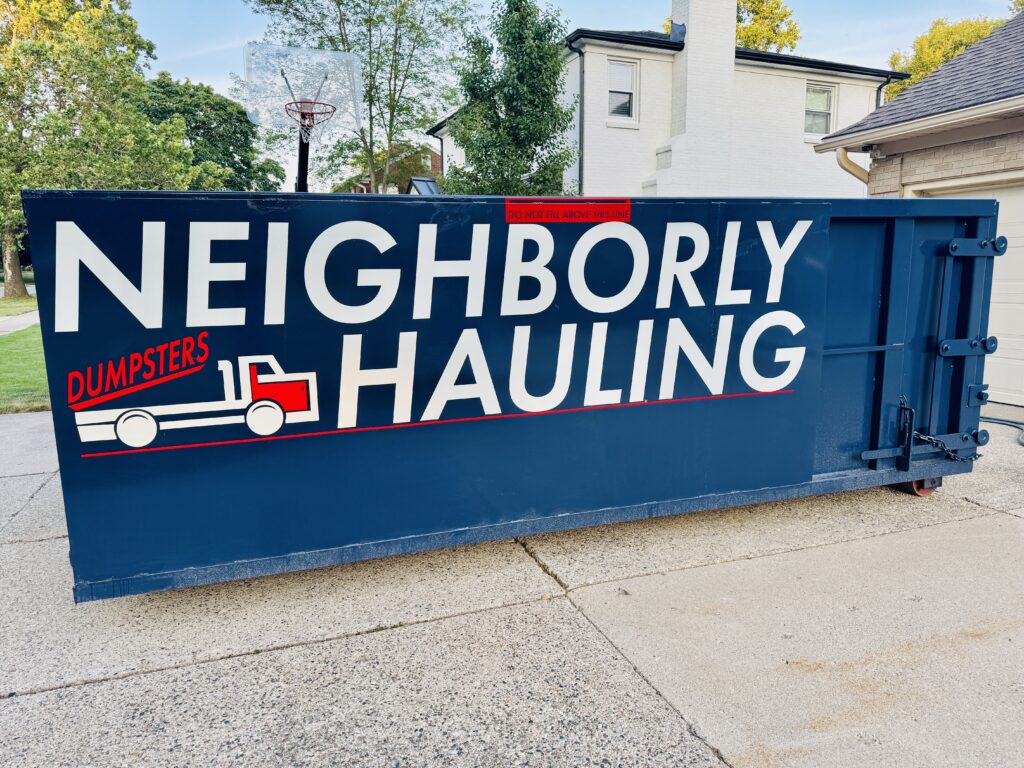 21 yard dumpster rental in Grand Rapids driveway with Neighborly Hauling branding