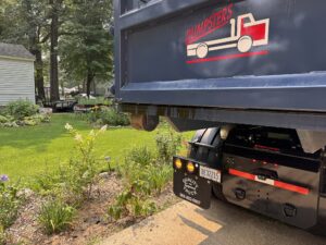 Neighborly Hauling dumpster placed with Rolliskate pad protecting residential driveway