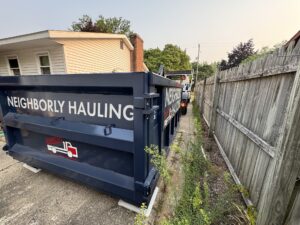 12 yard dumpster rental placed beside a fence in Grand Rapids residential lot