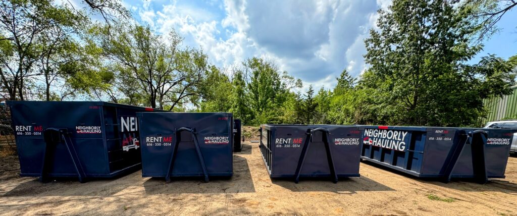Photograph of a Neighborly Hauling 17-yard dumpster being delivered into a residential Grand Rapids driveway. The bin is set on HDPE Rolliskate pads to prevent surface damage. This container holds ~5–6 pickup truck loads and is ideal for multi-room renovations, roofing tear-offs, and siding projects.