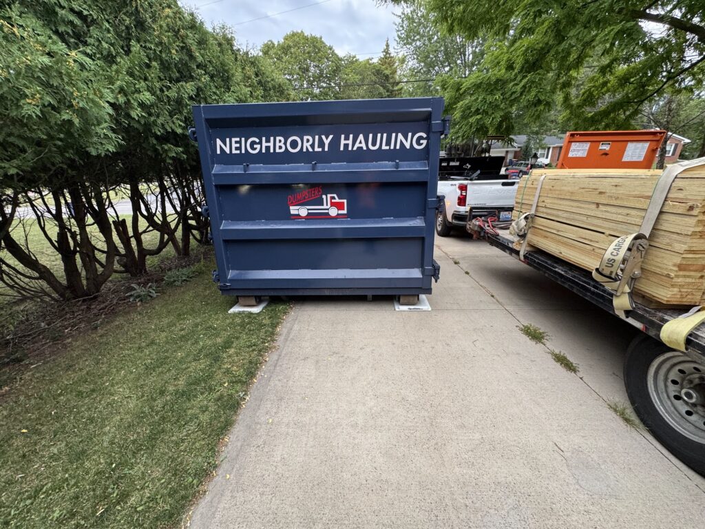 Neighborly Hauling 25-yard dumpster rental in Grand Rapids driveway with Rolliskate pads for protection