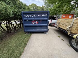 Neighborly Hauling 25-yard dumpster rental in Grand Rapids driveway with Rolliskate pads for protection