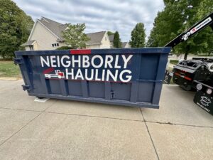 12 yard dumpster rental in Grand Rapids driveway with Neighborly Hauling logo