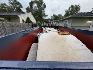 Neighborly Hauling dumpster loaded with drywall, furniture, and construction debris in Grand Rapids driveway