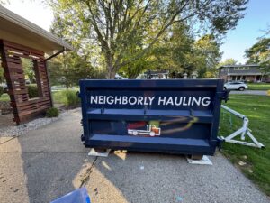 Neighborly Hauling dumpster placed on driveway protection pads in a residential driveway.